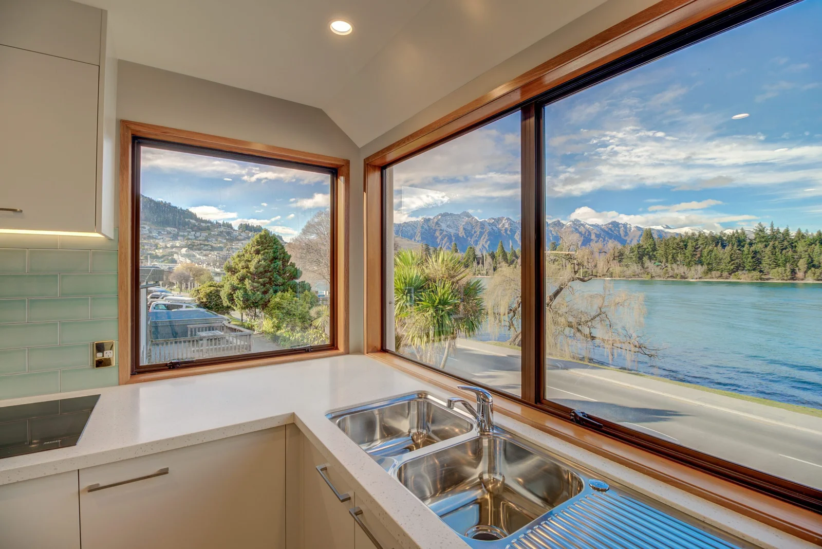 Modern kitchen with a large window overlooking a lake and mountains