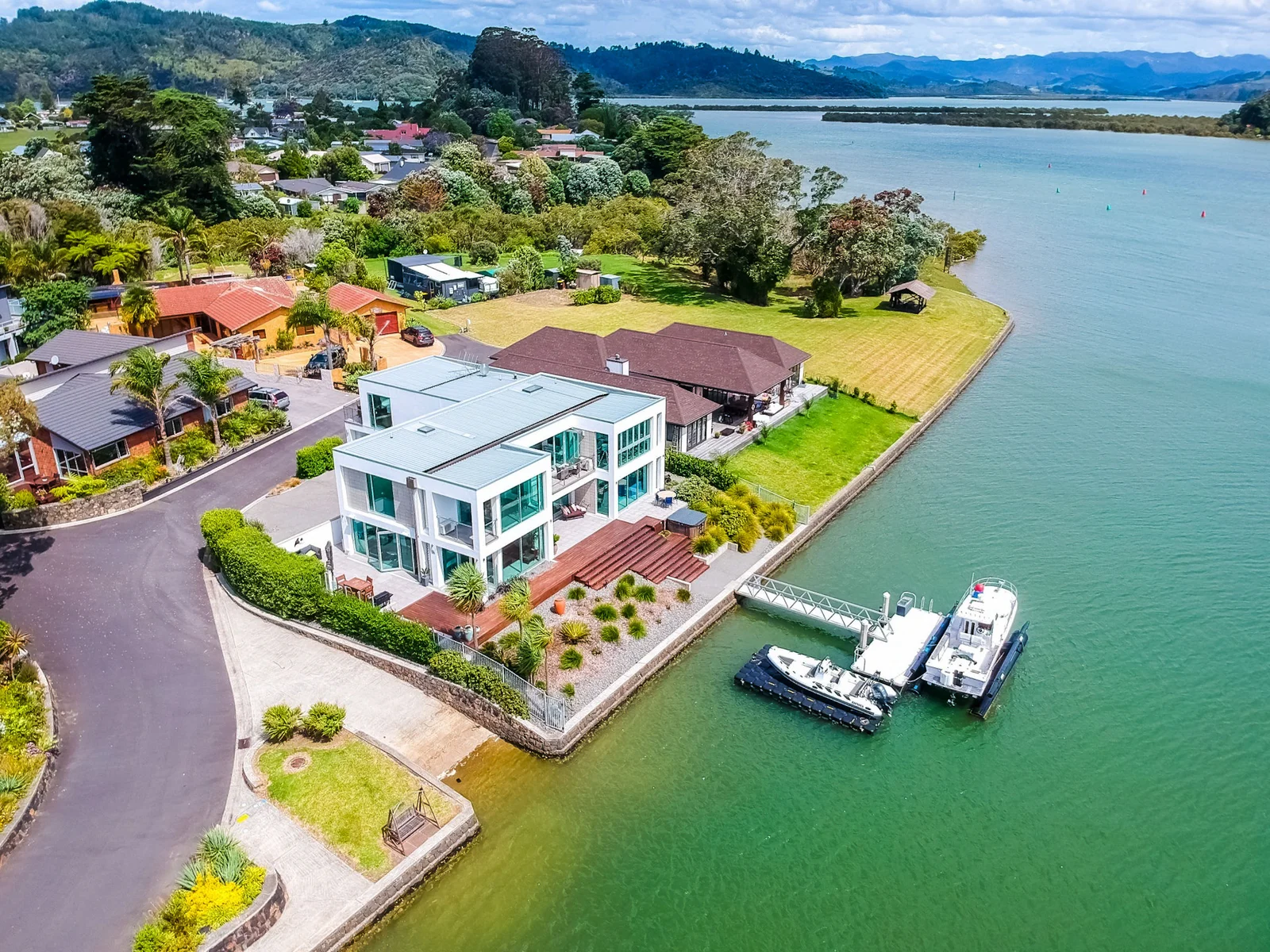Aerial view of a modern house with a dock on a waterfront