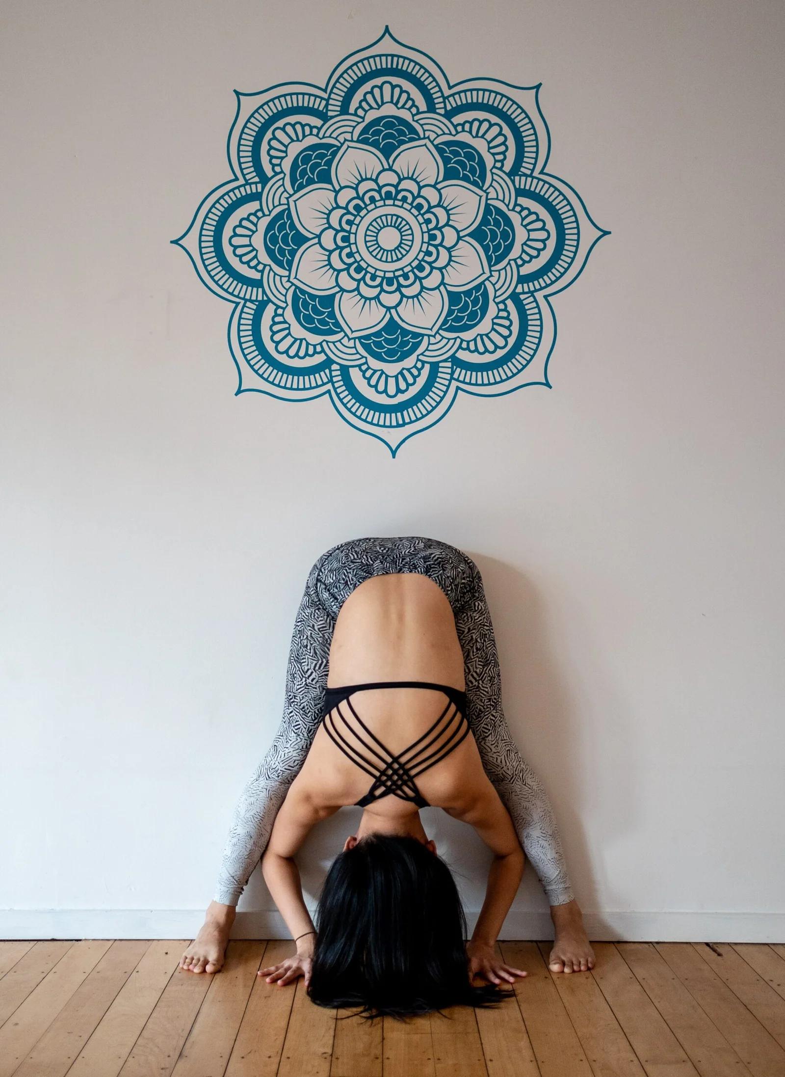 Person in yoga pose with mandala