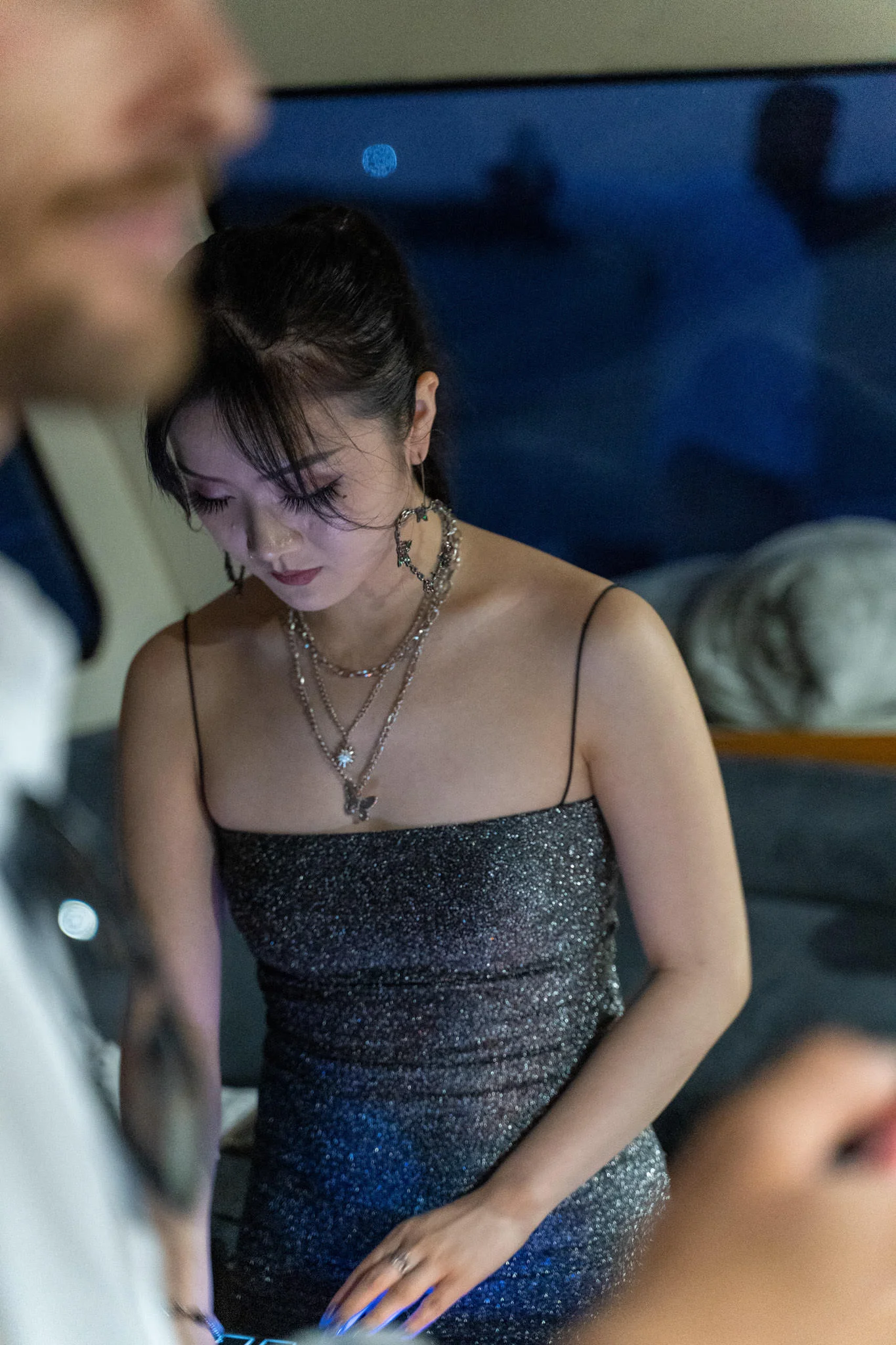 Young woman with necklaces looking down