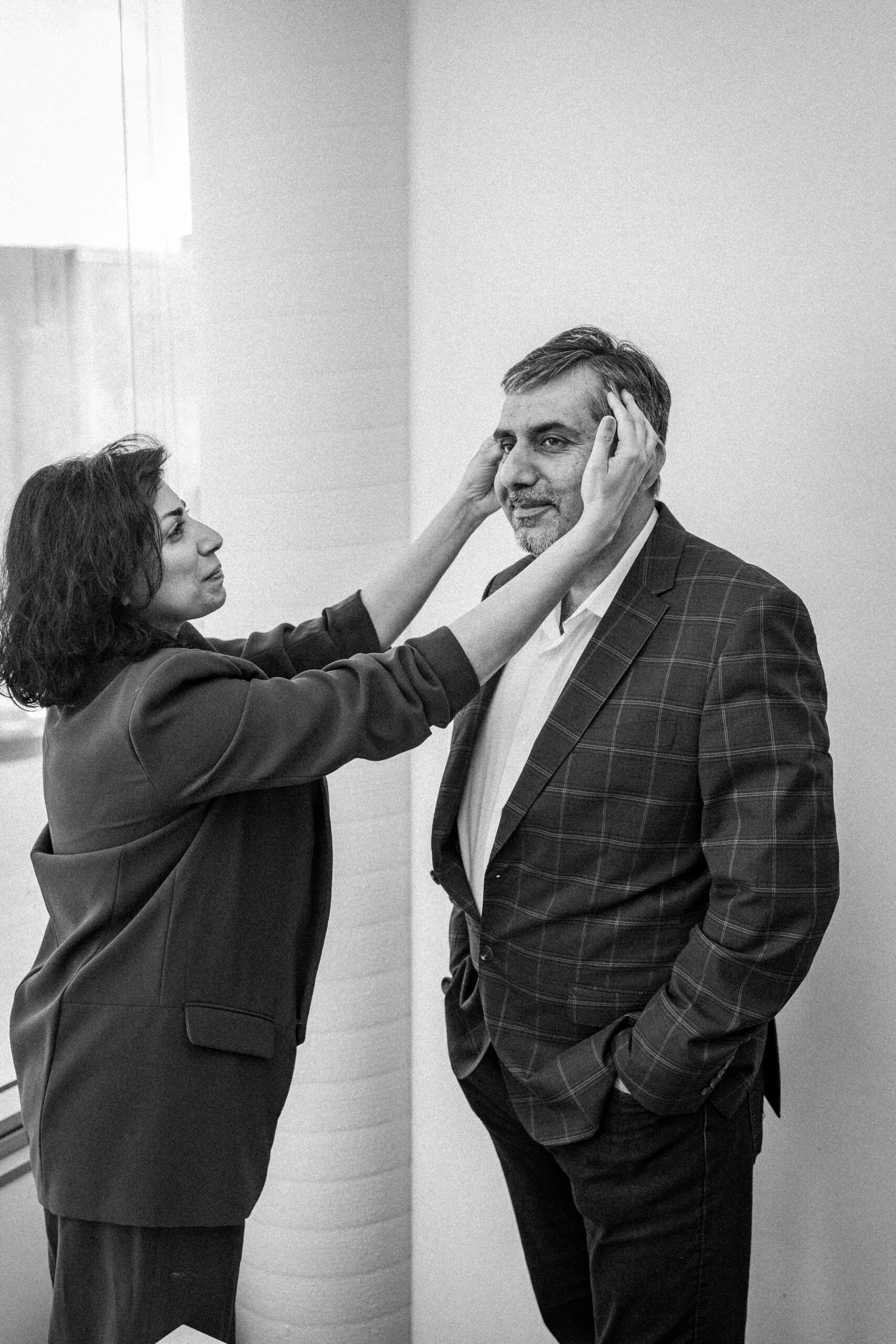 Woman adjusting man's hair