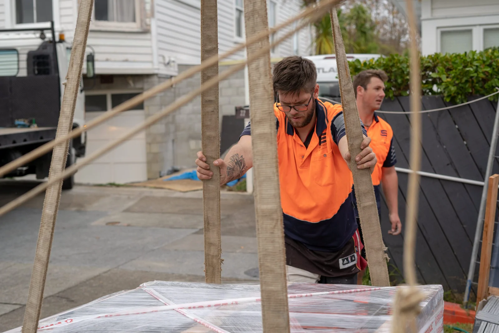 Construction workers in high-vis gear working with wooden posts