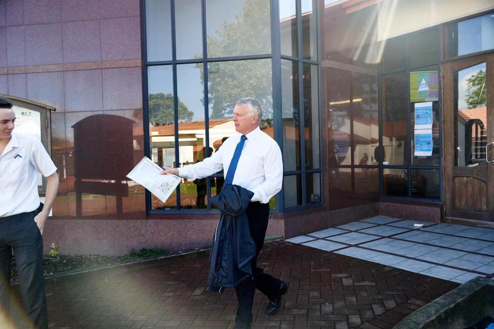 Business professional in white shirt and blue tie outside modern building