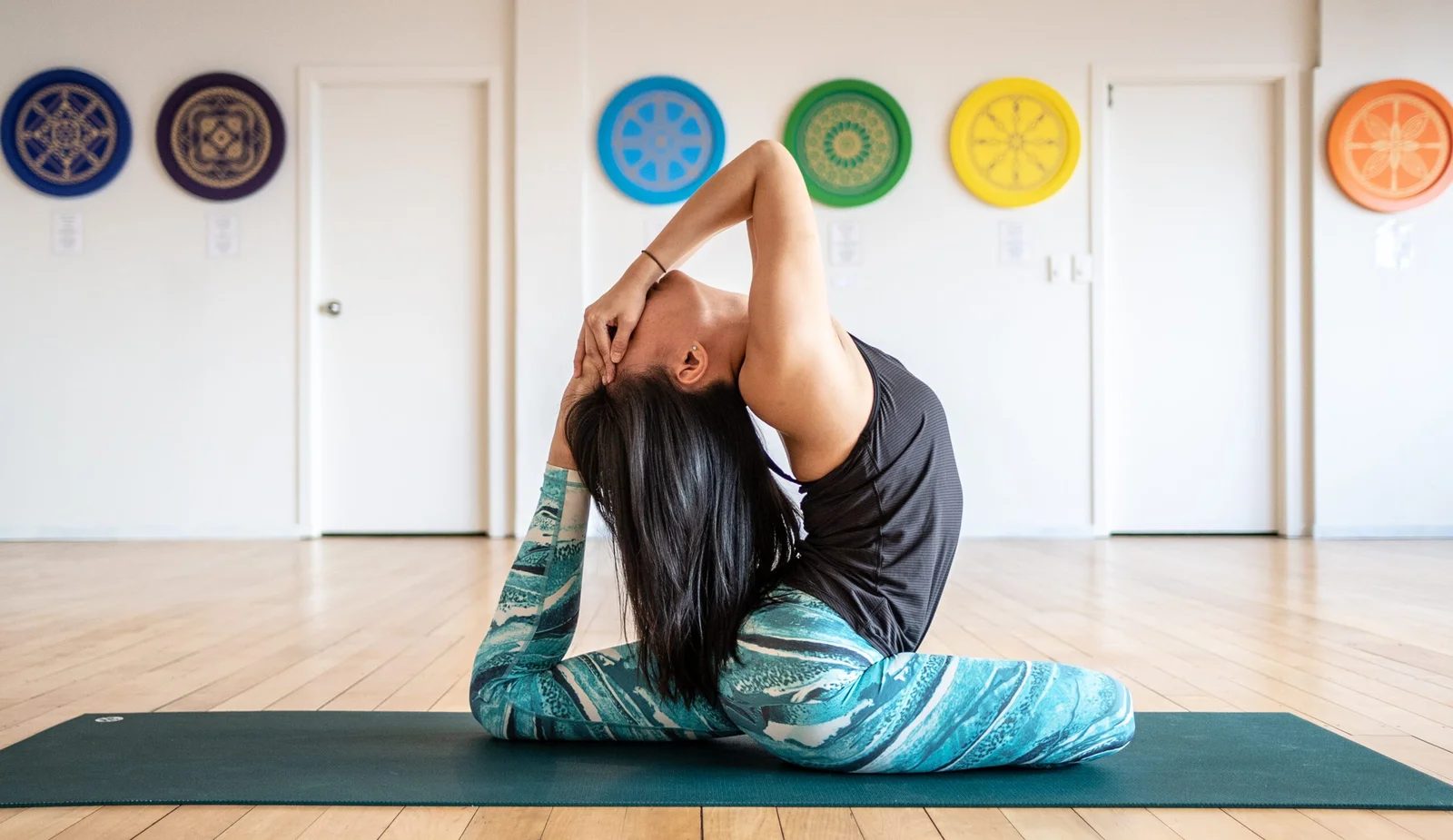 Person doing yoga pose in studio with colorful circular decorations
