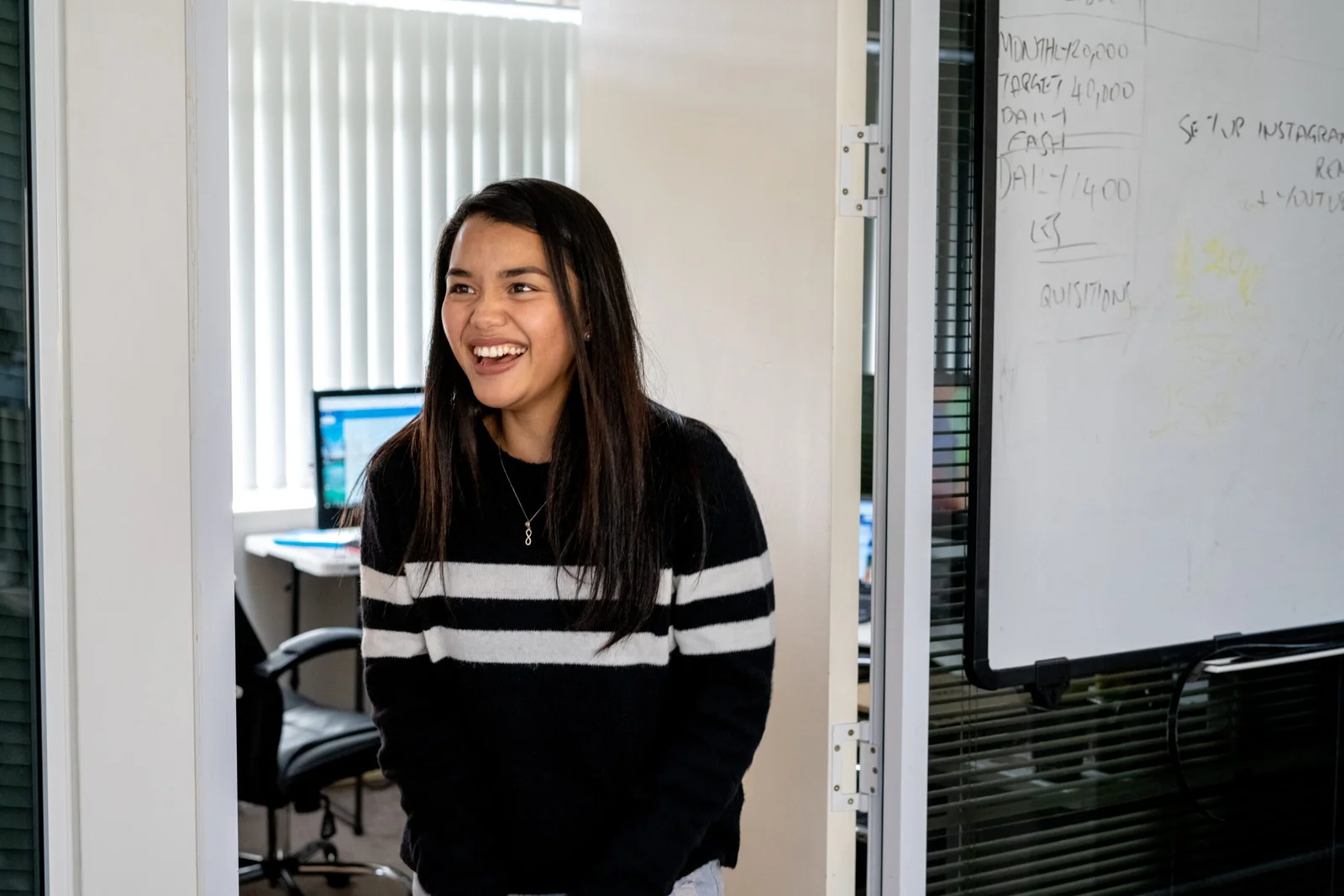 Young woman smiling in an office doorway