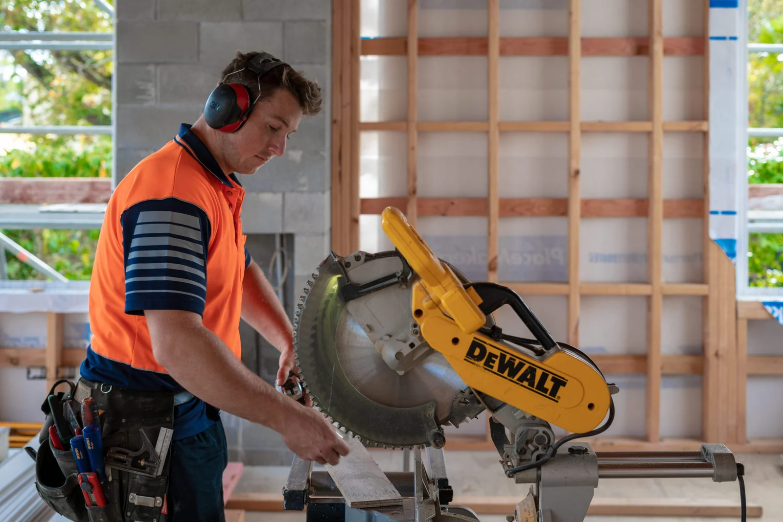 Construction worker operating a miter saw