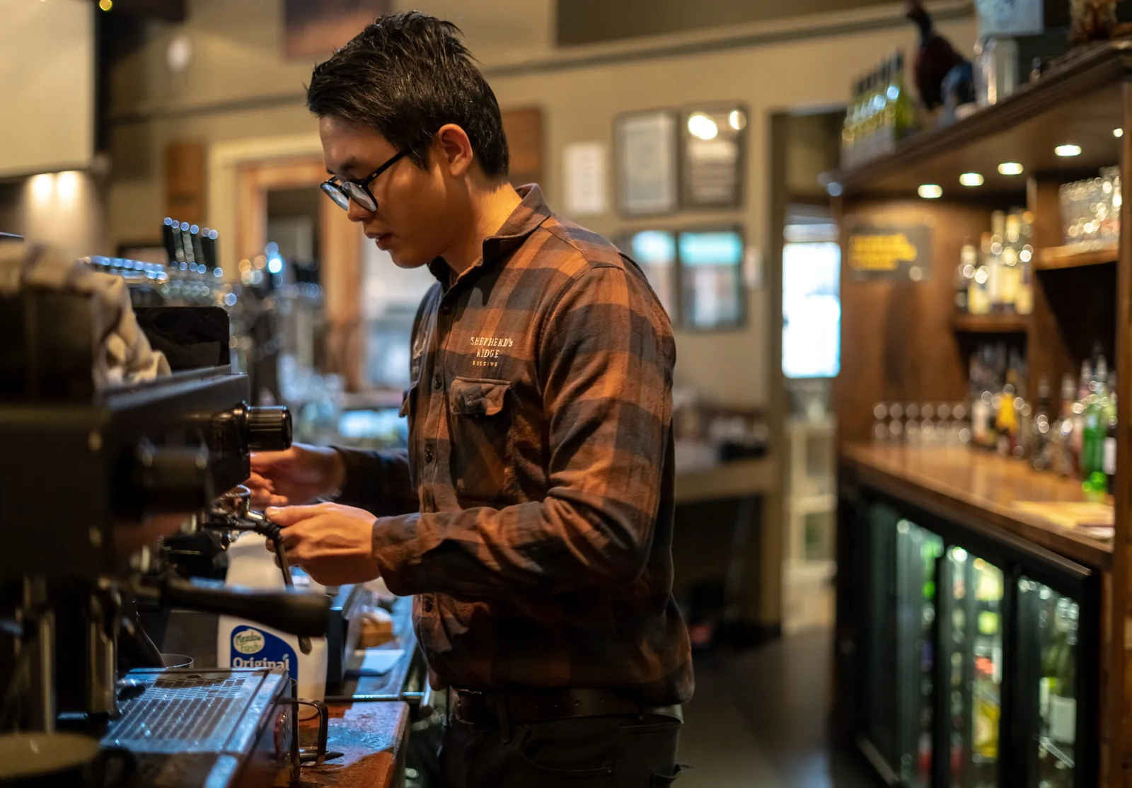 Man operating an espresso machine in a cafe